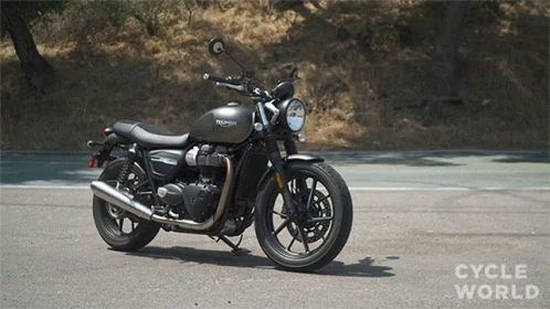 A Triumph Motorcycle Is Parked On The Road GIF