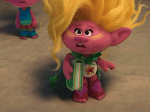 A Troll Doll With Blonde Hair Is Holding A Gift GIF