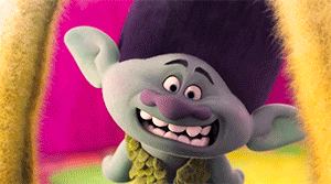 A Troll With A Purple Nose Is Smiling And Wearing A Green Scarf GIF
