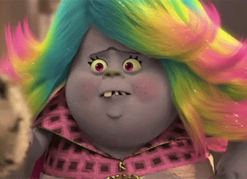 A Troll With A Rainbow Colored Wig Is Making A Surprised Face . GIF