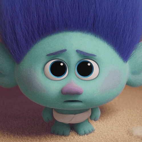 A Troll With Blue Hair And A Purple Nose Has A Sad Look On His Face GIF