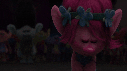 A Troll With Pink Hair And Blue Flowers On It GIF