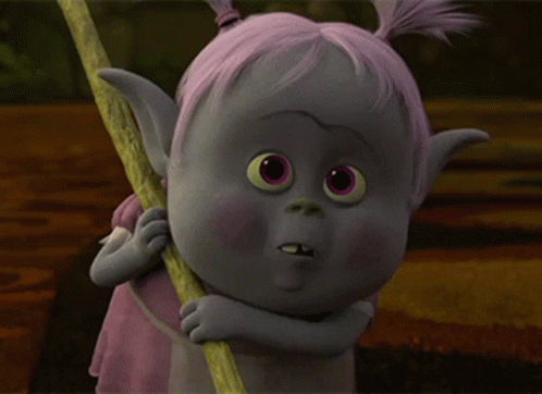 A Troll With Pink Hair Is Holding A Stick And Making A Funny Face GIF