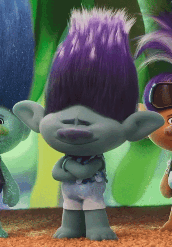 A Troll With Purple Hair Is Standing With His Arms Folded GIF