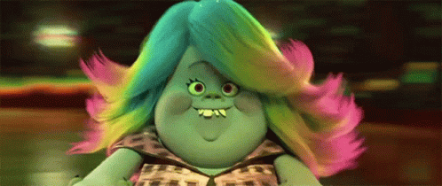 A Troll With Rainbow Hair Is Smiling And Wearing A Leopard Print Dress . GIF