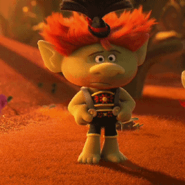 A Troll With Red Hair And A Top Hat Is Standing In The Desert GIF