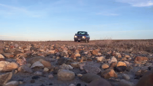 A Truck Is Driving Down A Rocky Road With A License Plate That Says ' Aa ' On It GIF