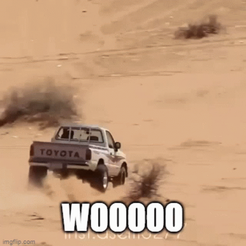 A Truck Is Driving Down A Sand Dune And The Words Woooom Are On The Bottom GIF