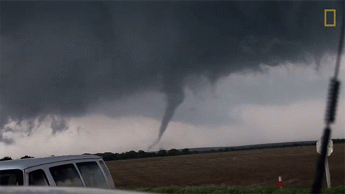 A Van Is Parked In Front Of A Tornado With A National Geographic Logo In The Corner GIF