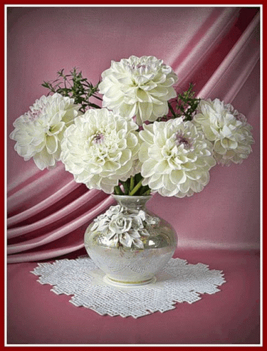 A Vase Filled With White Flowers Is Sitting On A Table GIF