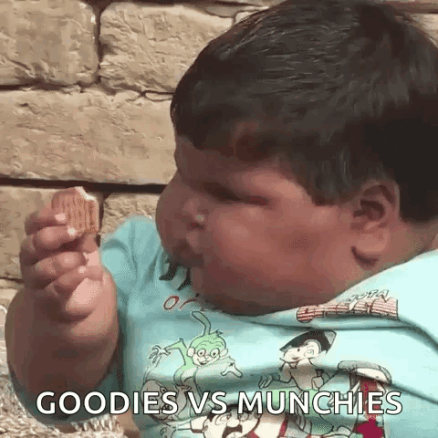 A Very Fat Boy Is Eating A Cookie With The Words Goodies Vs Munchies Written On His Shirt . GIF