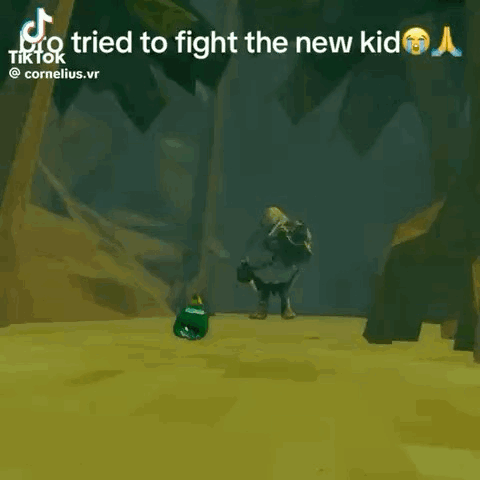 a video game character is laying on the ground in front of a rock .