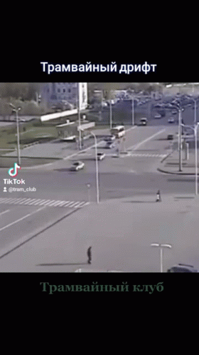 A Video Of A Man Walking Down A Street In A City With Russian Writing On The Bottom GIF