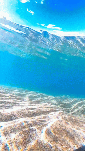A View Of The Ocean From The Bottom Of The Sand GIF