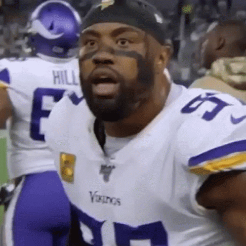 A Vikings Football Player With A Beard Is Wearing A White And Purple Uniform . GIF