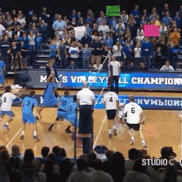 A Volleyball Game Is Being Played In Front Of A Crowd With A Sign That Says M 'S Volleyball Champion GIF