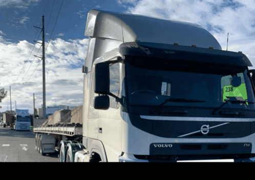 A Volvo Truck Is Parked On The Side Of A Road GIF
