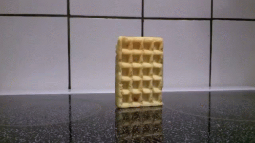 A Waffle Is Sitting On Top Of A Black Stove Top GIF