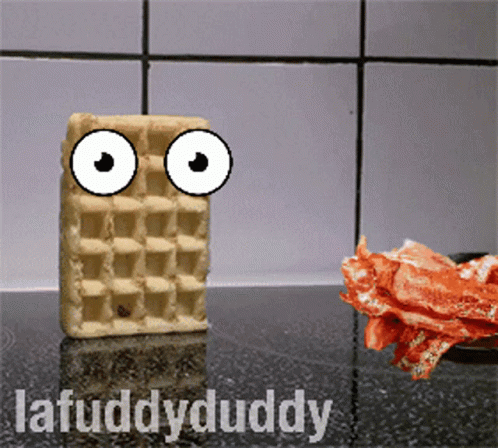 A Waffle With Googly Eyes Is Standing Next To Bacon GIF