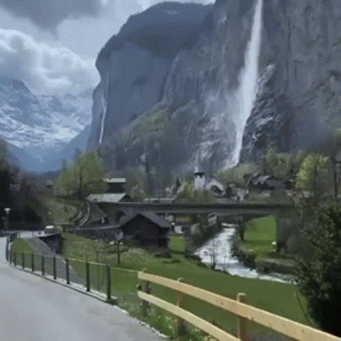 A Waterfall In The Middle Of A Mountain Valley GIF