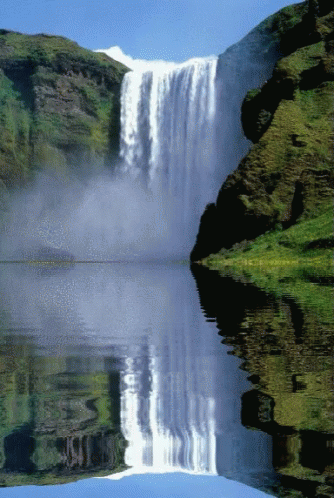 A Waterfall Is Reflected In A Lake Surrounded By Mountains GIF