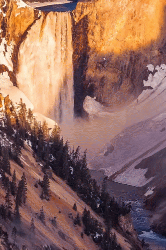 A Waterfall Is Surrounded By Trees And Rocks GIF