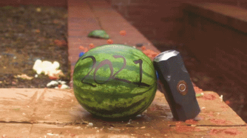 A Watermelon With The Year 2021 Painted On It Sits Next To A Hammer GIF