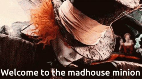 A Welcome To The Madhouse Minion Sign With A Picture Of Mad Hatter GIF