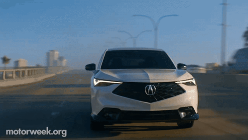 A White Acura Car Is Driving Down A Highway With Motorweek.org Written On The Bottom GIF