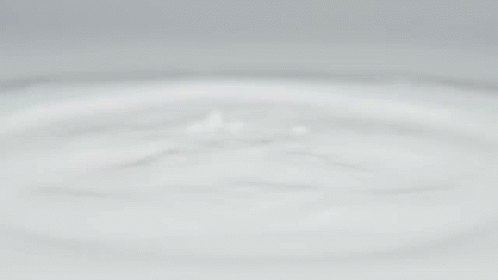 A White Apple Iphone Is Floating On A White Surface GIF