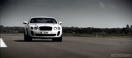 A White Bentley Is Driving Down A Road With A License Plate That Says 21 Md GIF
