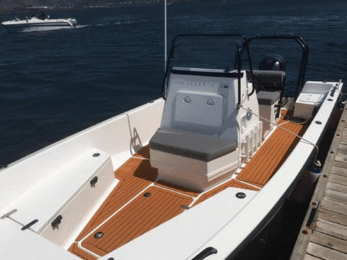 A White Boat With A Yamaha Motor Sits On A Dock GIF
