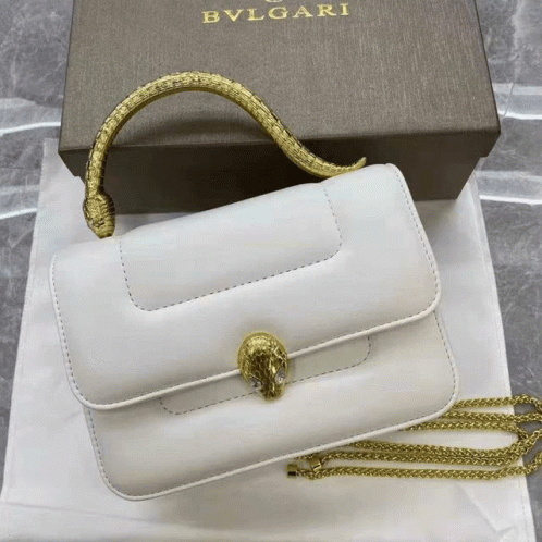 A White Bvlgari Purse With A Gold Handle GIF
