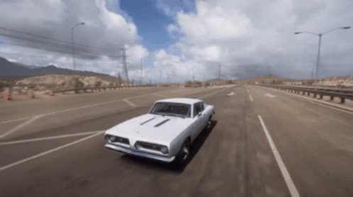 A White Car Is Driving Down A Highway In The Desert GIF