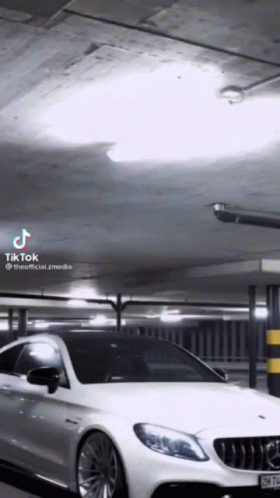 A White Car Is Parked In A Parking Garage With A Tik Tok Watermark GIF
