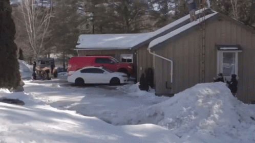 A White Car Is Parked In Front Of A Brown House GIF