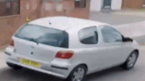 a white car is parked on the side of the road