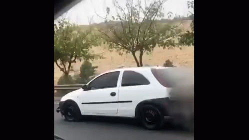 A White Car With Smoke Coming Out Of It 'S Tire GIF