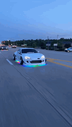 A White Car With The Word Libertyland On The Front Is Driving Down A Street GIF