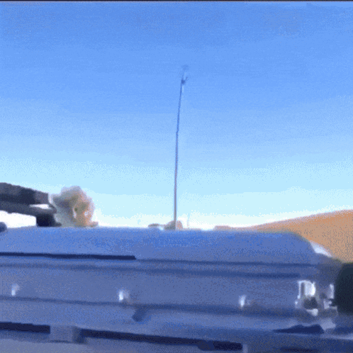 A White Coffin Is Sitting On Top Of A Roof With A Blue Sky In The Background GIF