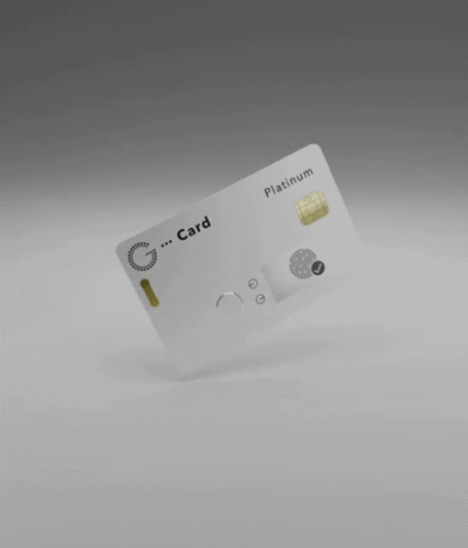 A White Credit Card Is Floating In The Air On A Gray Surface . GIF