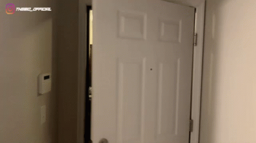 A White Door Is Open In A Room With The Word Official On The Wall GIF