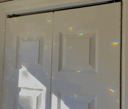 A White Door With A Reflection Of A Rainbow GIF