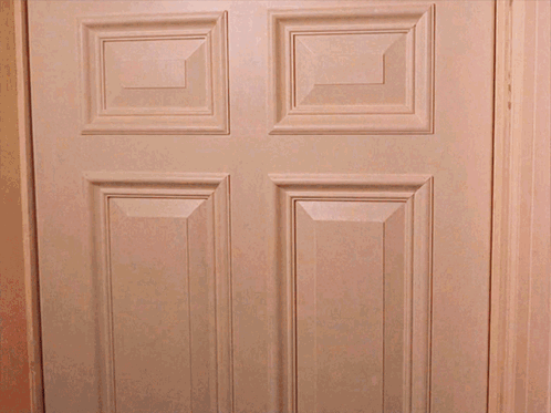 A White Door With Four Squares On It Is Open To A Dark Room GIF