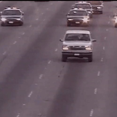 A White Ford Truck Is Driving Down A Highway With A License Plate That Says ' Lc ' GIF