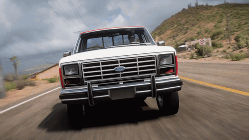 A White Ford Truck Is Driving On A Desert Road GIF