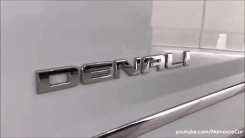 A White Gmc Denali Suv Is Parked In A Parking Lot GIF