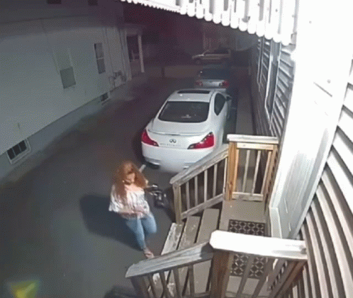 A White Infiniti Is Parked In A Driveway Next To Some Stairs GIF