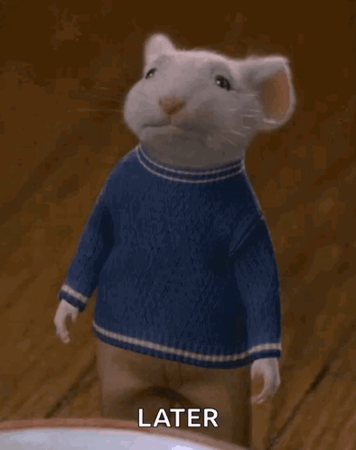 A White Mouse Wearing A Blue Sweater And Pants Is Waving . GIF