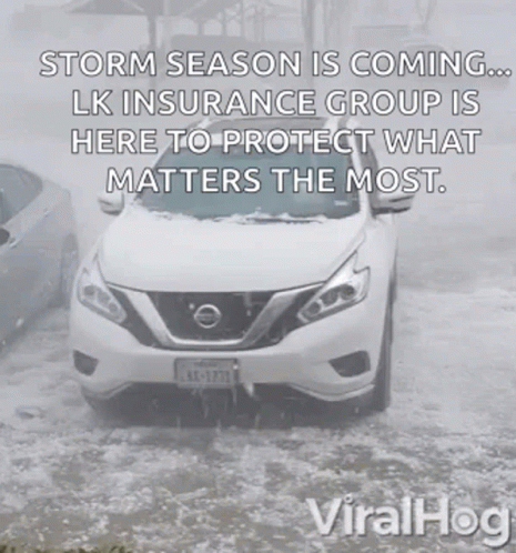 A White Nissan Car Is Driving Through A Snowy Road . GIF